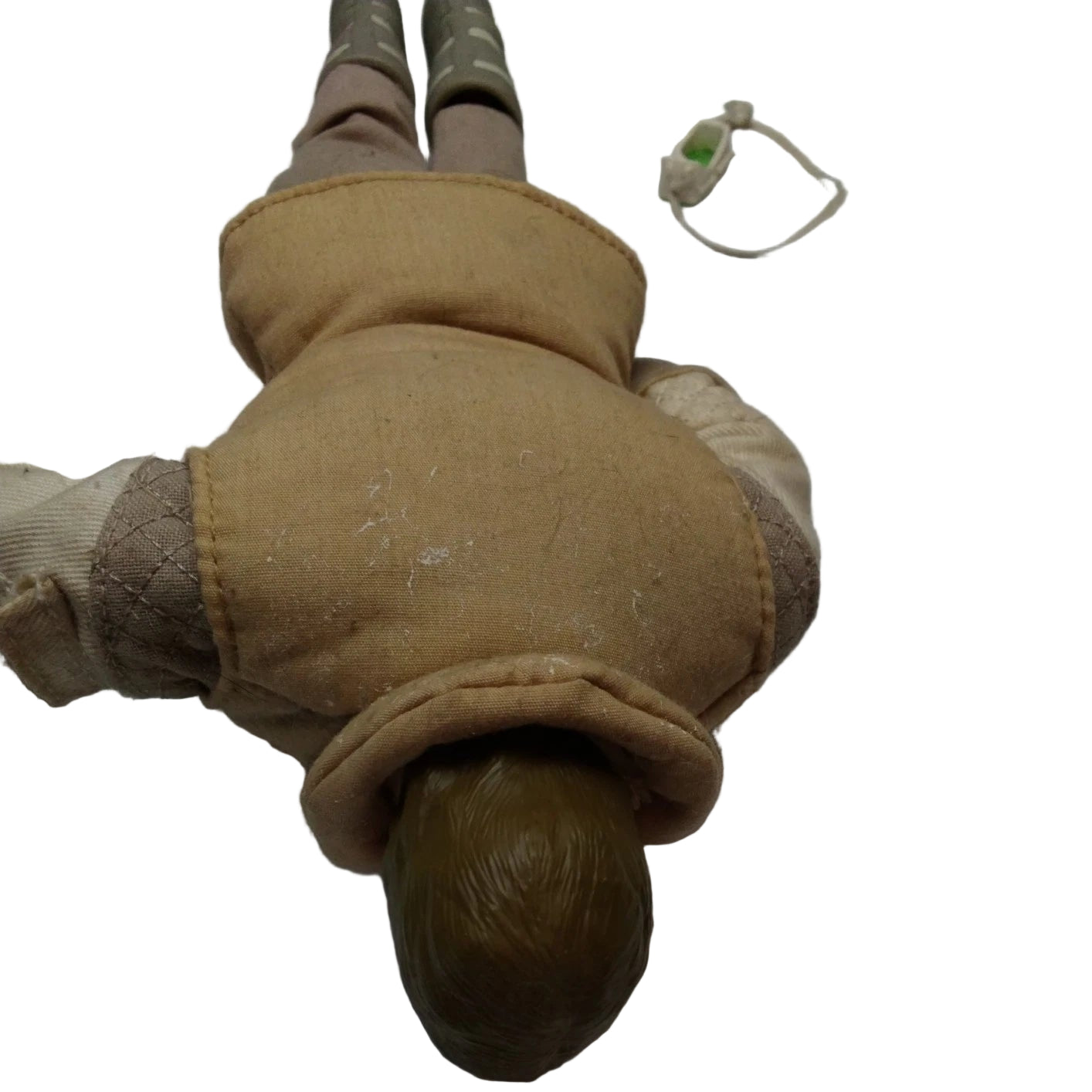 Vintage doll with tan coat and brown boots on a white surface